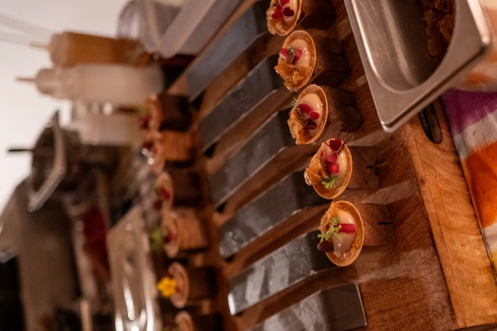 Une rangée de tartelettes dressées sur une planche en bois, en cuisine